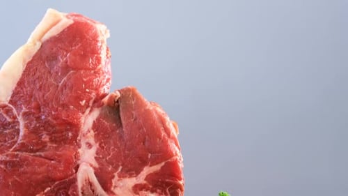 Raw meat and parsley on wooden table