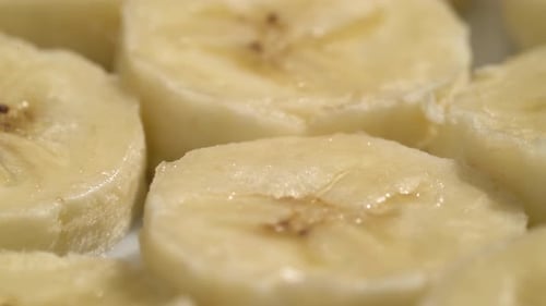 Primer plano de rebanadas de plátano, fondo macroalimentario de verano, vista superior de frutas. Rotar