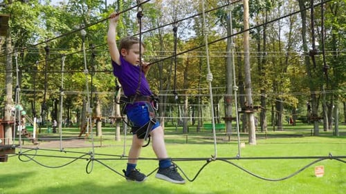 Child Walking on Rope Trail in Theme Park