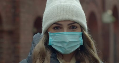 Close Up Portrait of a Beautiful Young Woman in a Hat Wearing Protective Medical Face Mask and