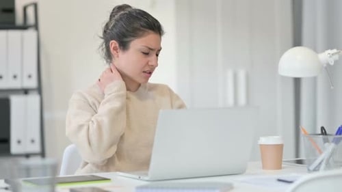 Adult Rubbing Neck at Desk with Laptop
