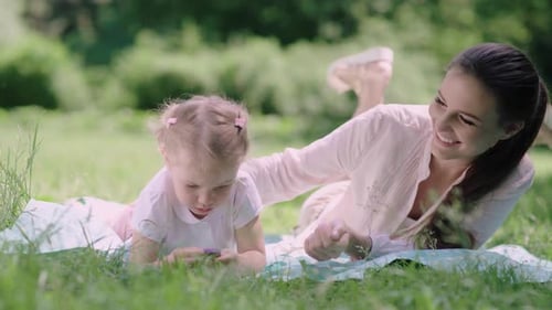 Family Time. Mother And Daughter Resting On Blanket At Park