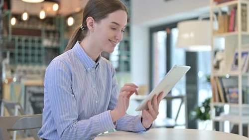 Digital Tablet Use By Beautiful Young Businesswoman in Cafe