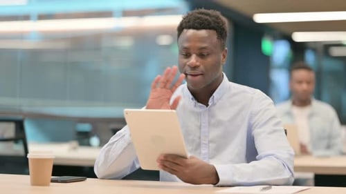 African Businessman Making Video Call on Tablet in Office