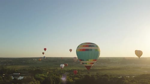 Hot Air Balloons Floating Over Green Countryside