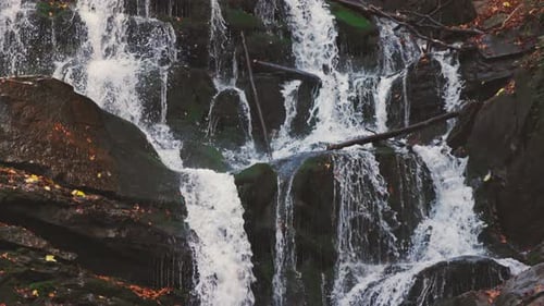 Waterfall Falling Down Mountain Slope in Autumn Forest