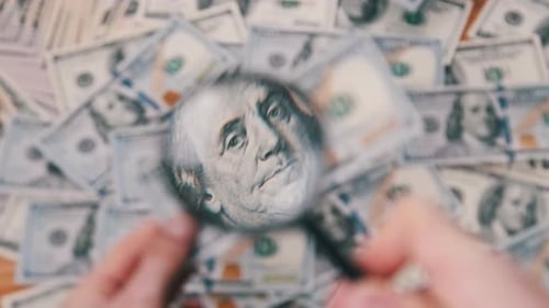 Inspecting US Currency with Magnifying Glass