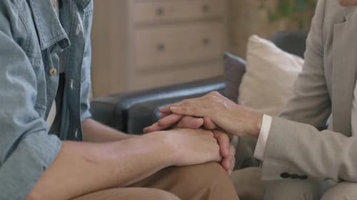 Supportive Adult Gently Holds Young Adult's Hands