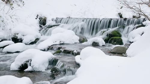 Wonderful Frozen Foot of a Waterfall with a Powerful Stream of Water at Winter Carpathian Mountains