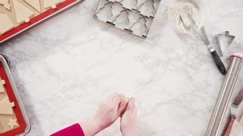 Flat lay. Cutting out sugar cookies with giant Christmas cookie cutter.