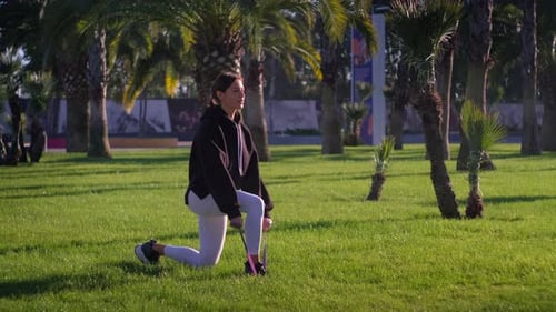 Woman Exercising with Resistance Band in Tropical Park