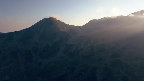 Un amplio Zumbido aéreo que se inclina lentamente hacia arriba desde el campamento en la cima de las montañas. El tiro termina con el horizonte completo