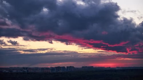 Un gros nuage de pluie avec un reflet de la lumière du soleil rouge au lever du soleil, timelapse