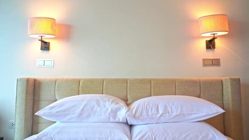 Stylish Hotel Room Bed with Pillows and Lamps