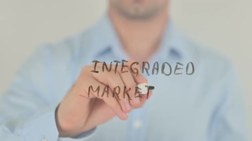 Man Writes Integrated Marketing on Clear Surface