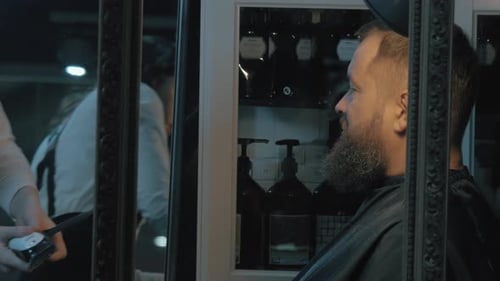 Stylish Woman Trimming Man's Beard in Barber Shop