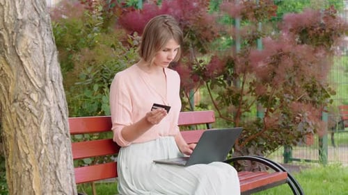 Woman Enjoys Online Shopping in the Park