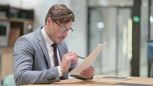 Businessman Reading Documents in Office