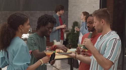 Group of Multiethnic Friends Clinking Their Glasses at Terrace Party