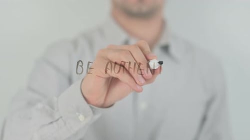 Man Writes "Be Authentic" on Clear Surface