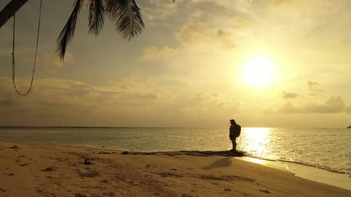Modern smiling lady on photoshoot in the sun on the beach on summer white sandy and blue background