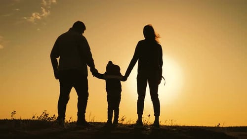 Family Silhouette Holding Hands at Sunset