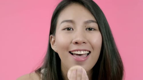 Smiling Woman Applies Makeup with Sponge