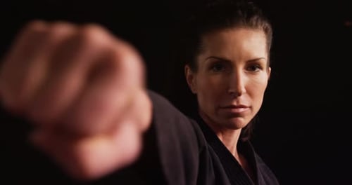 Woman Punching in Black Martial Arts Uniform