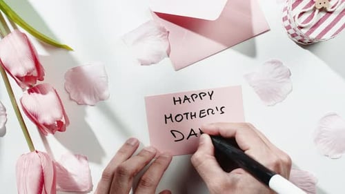 Writing Happy Mother's Day Card with Tulips and Gift