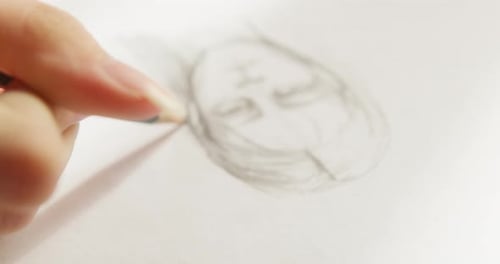Hand Drawing Face with Pencil Close Up