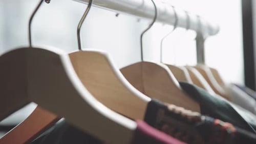Hand Selecting Shirt on Clothing Rack