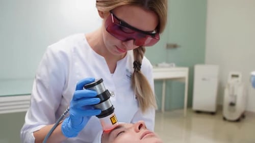 Woman Performs Laser Skin Treatment on Patient