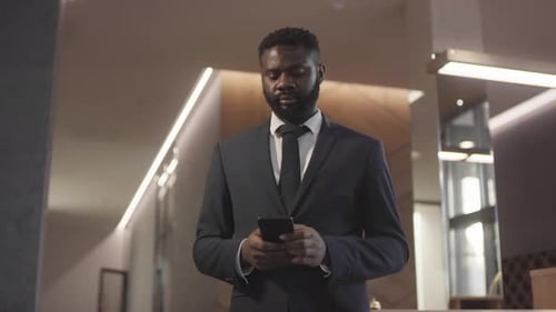 Black Man Using Phone in Hotel Lobby