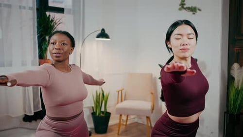 Women Exercising and Stretching Arms in Living Room