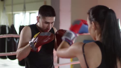 Woman Boxing With Trainer in Gym Ring