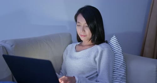Young Adult Woman Working at Night on Laptop