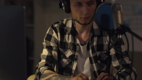 Man Recording Podcast in Home Studio at Night