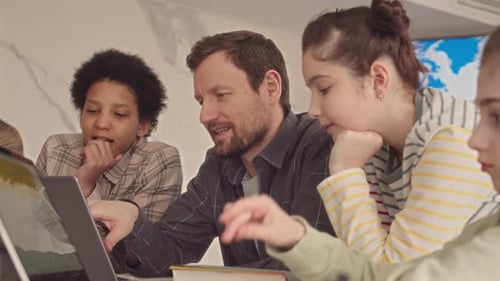School Teacher Showing Presentation on Laptop to Students