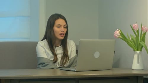 Woman Video Conferencing on Laptop at Home