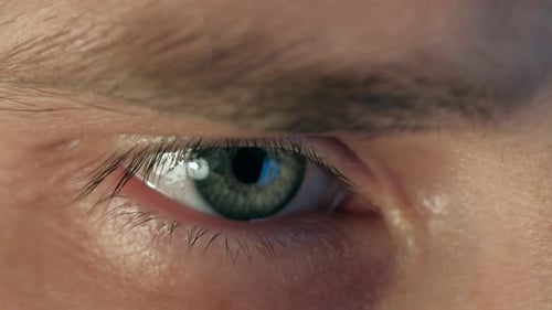 Nahaufnahme eines männlichen Auges, das auf den Laptop schaut.