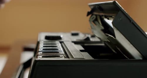 Männliche Hände extrahieren eine Audiokassette in ein Retro-Tonbandgerät