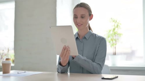 Woman Using Tablet While Sitting in Office