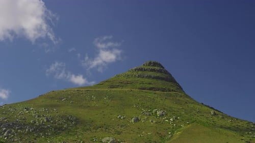 View of a Mountain Top Against the Clear Blue Sky with Silhouettes of Clouds