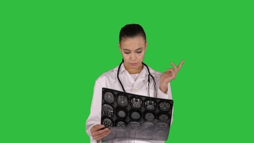 Female Doctor Examining Brain Scan on Green Screen