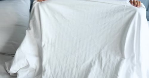 Happy Young Girl Playing Peekaboo in Bed