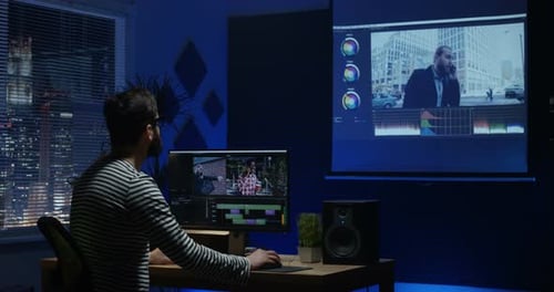 Joven sentado y editando Vídeo dentro de una habitación