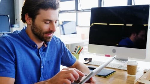 Man Works on Tablet in Modern Workplace