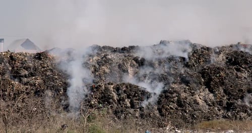 Close up of landfill with burning trash piles