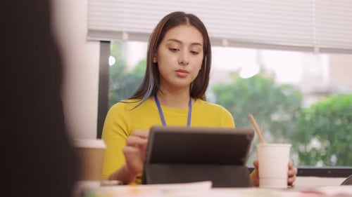 Young Woman Eating Noodles While Using Tablet