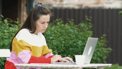 Woman Use Laptop in Outdoor Cafe